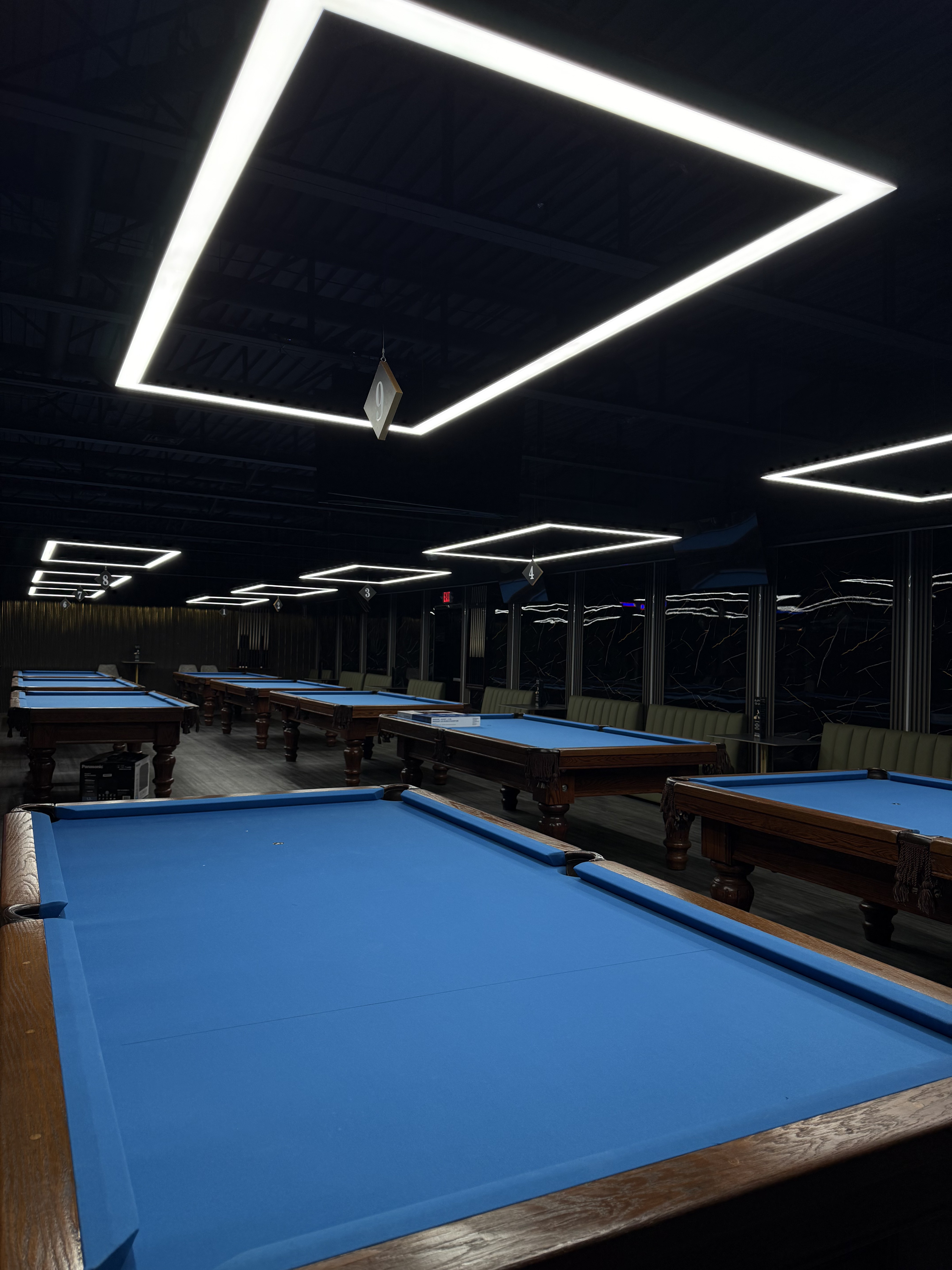 Boston pool tables under neon ceiling lights at King Billiards